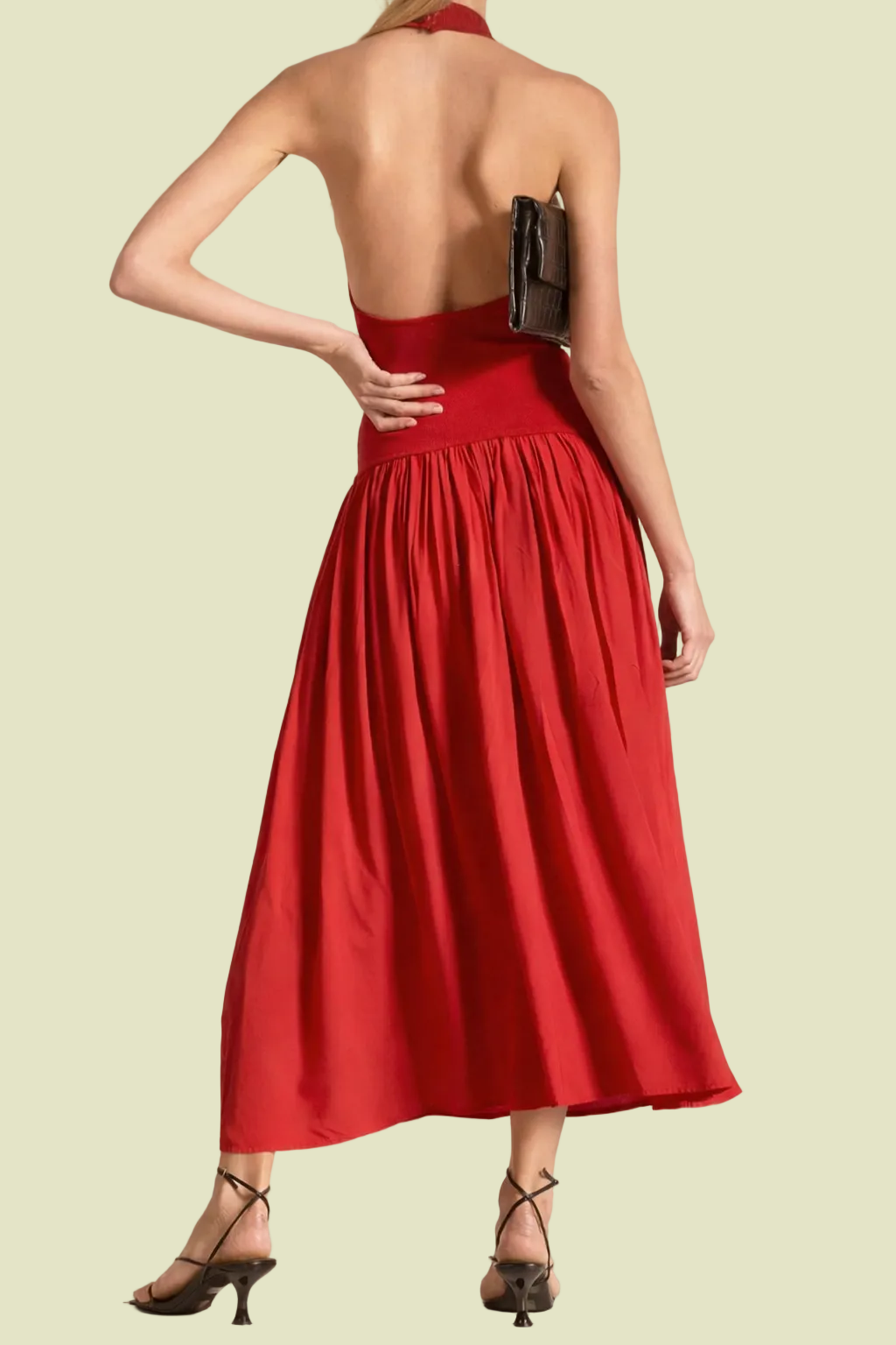 Red halter neck dress with open back on a beige background