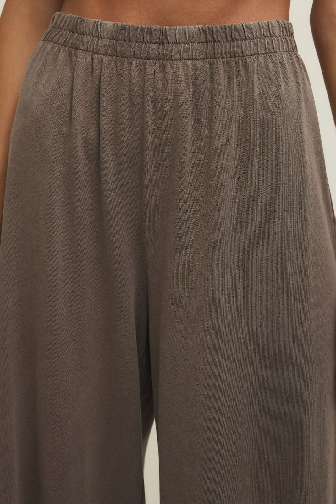 Brown pants with an elastic waistband on a neutral background