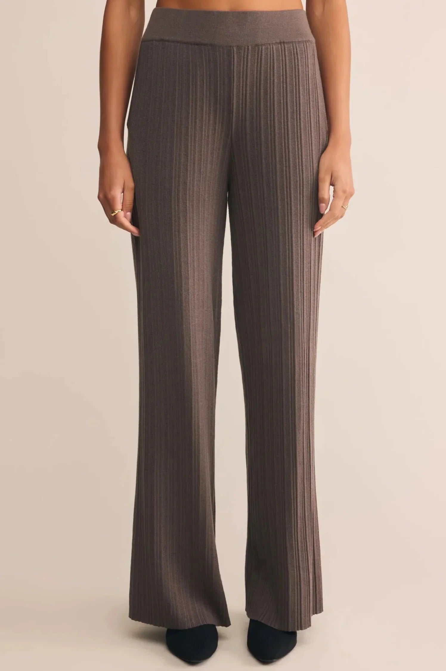 Brown pleated pants on a beige background