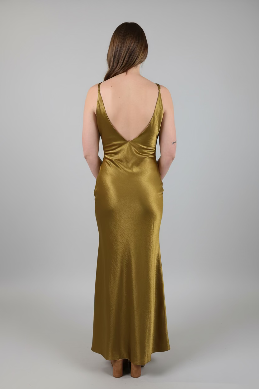 Person wearing a gold evening gown with a plain background