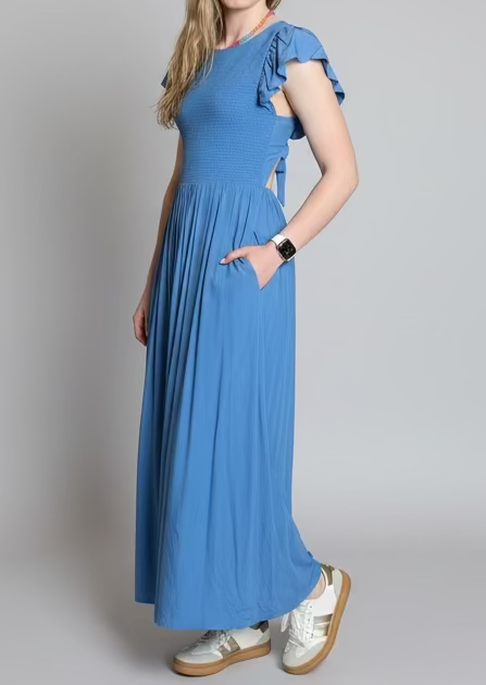 Woman in a blue maxi dress standing 