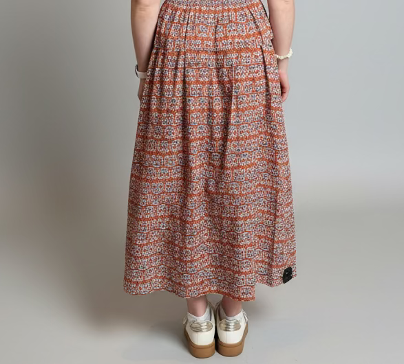 Woman wearing a patterned dress with a gray background