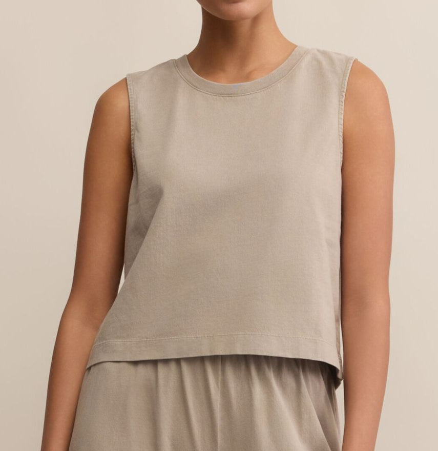Person wearing a beige sleeveless top and pants against a neutral background