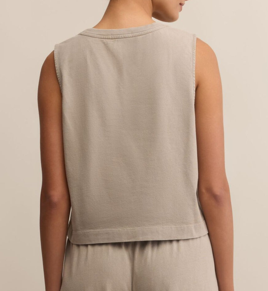 Person wearing a beige sleeveless top and pants on a plain background