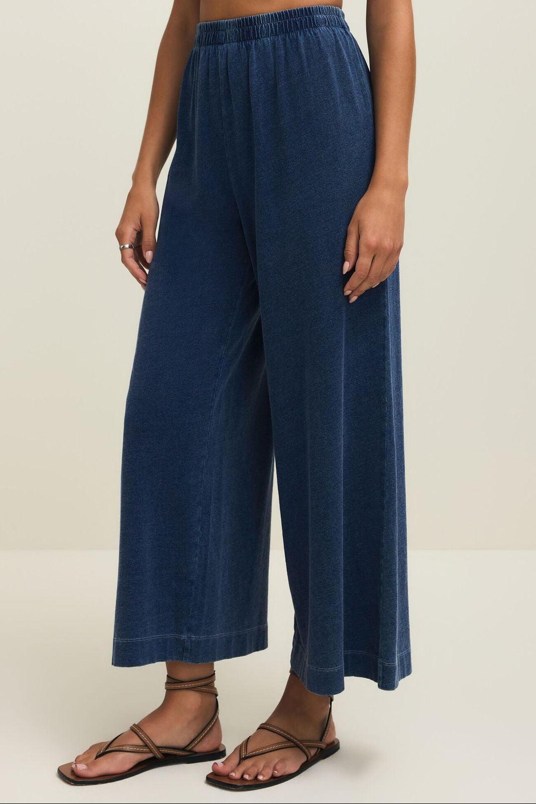 Person wearing blue wide-leg pants on a plain background