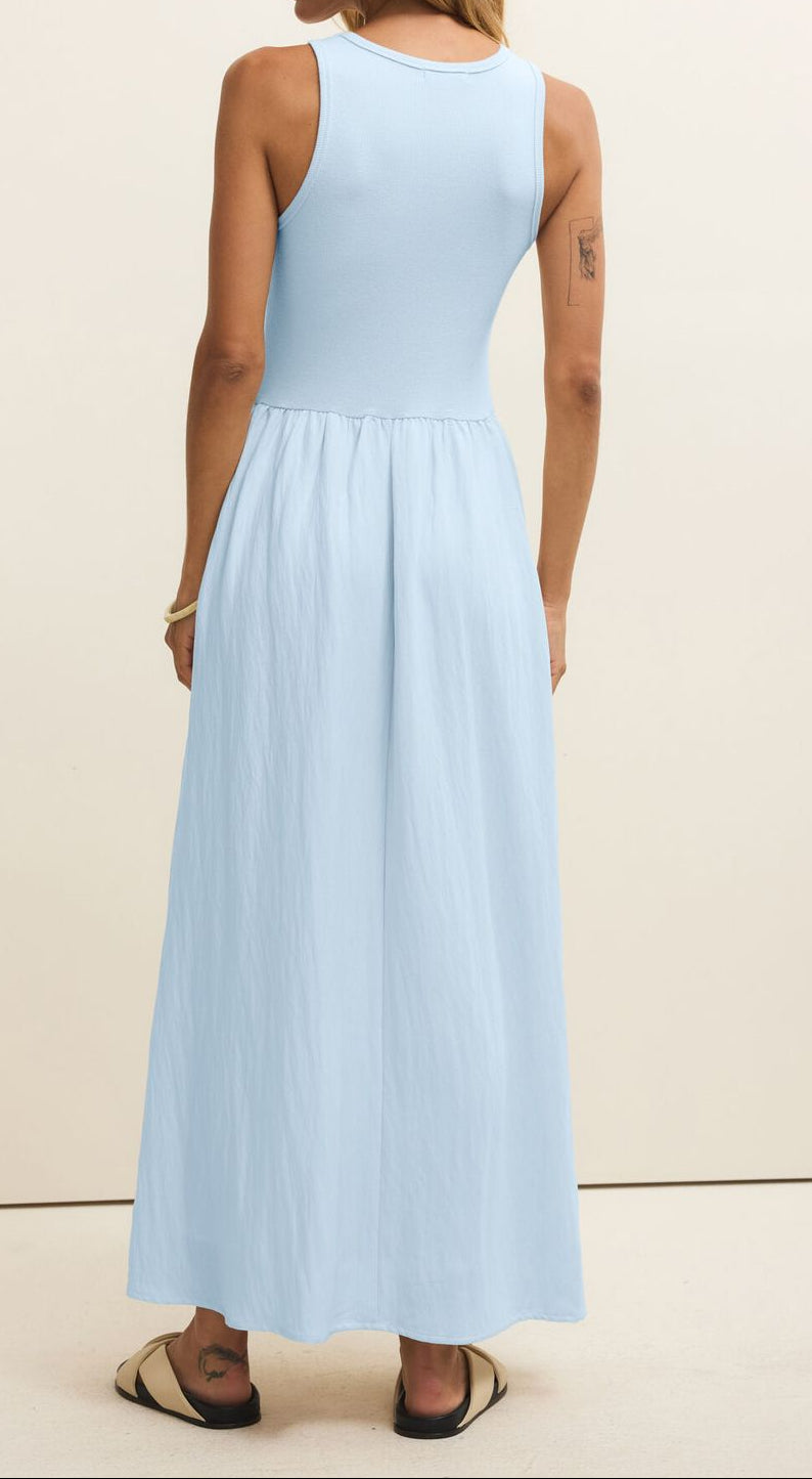 Woman wearing a light blue dress against a beige background