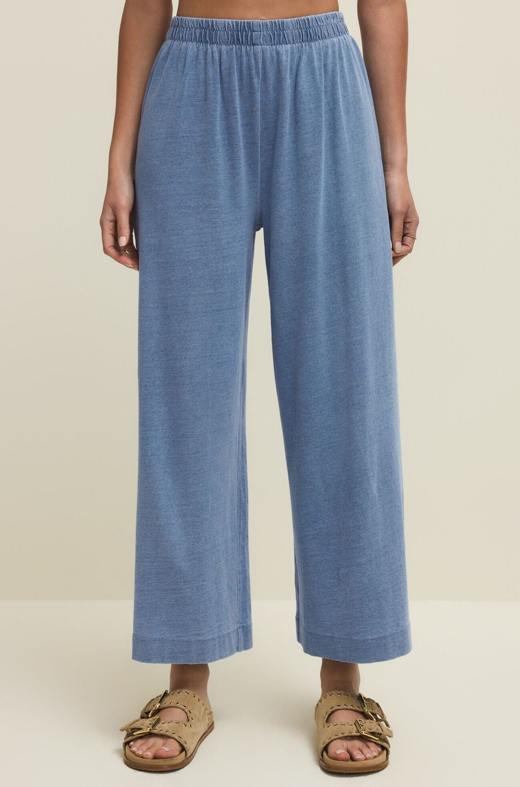 Person wearing blue pants on a beige background