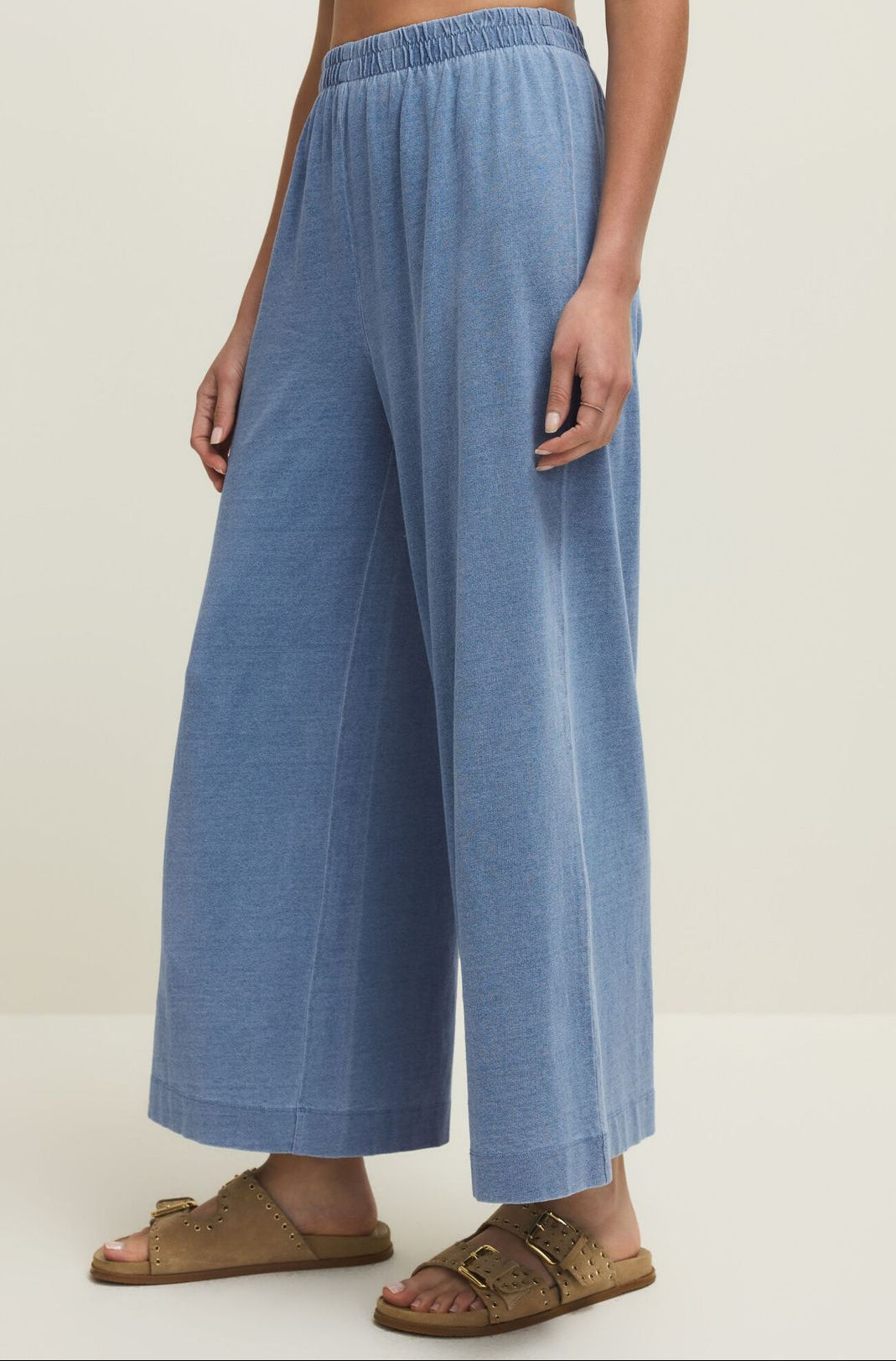 Person wearing blue wide-leg pants on a plain background