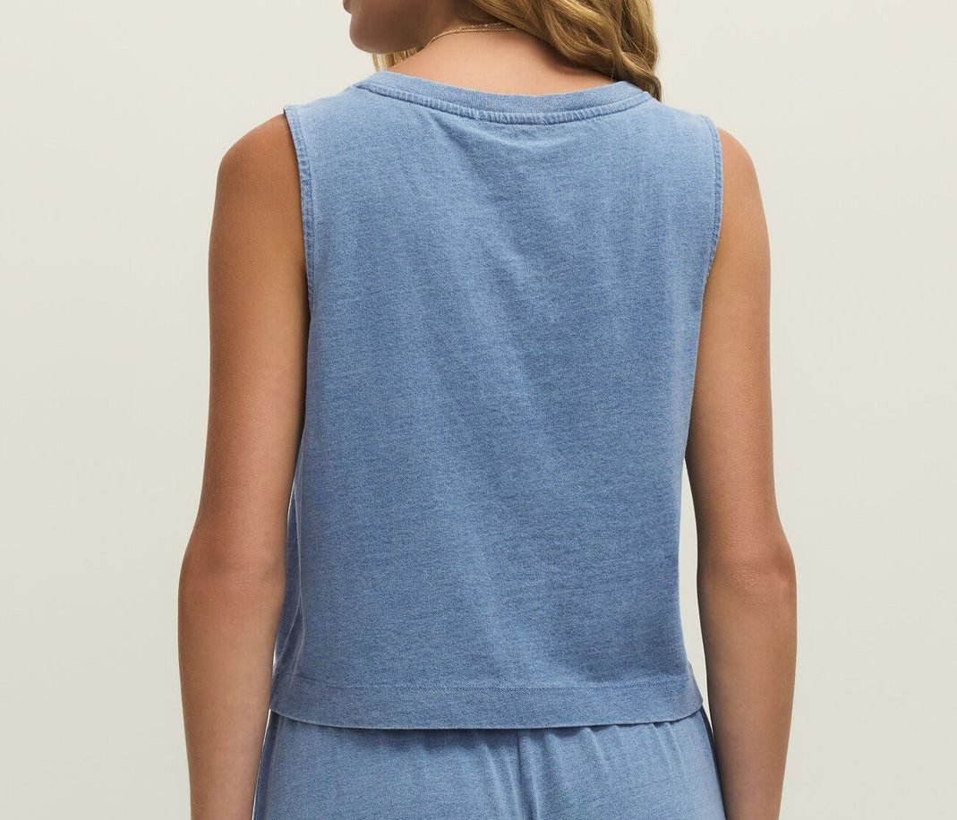 Woman wearing a blue sleeveless top and pants set on a beige background