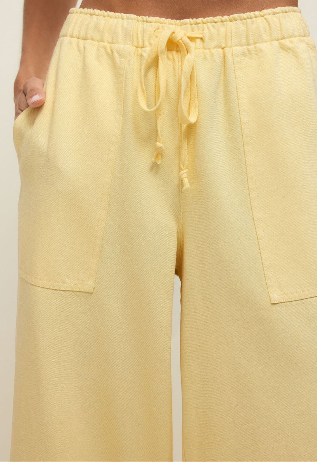Yellow pants with a drawstring waist on a plain background