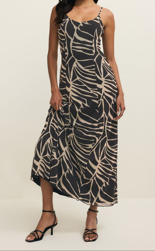 Woman wearing a black and beige patterned dress on a white background