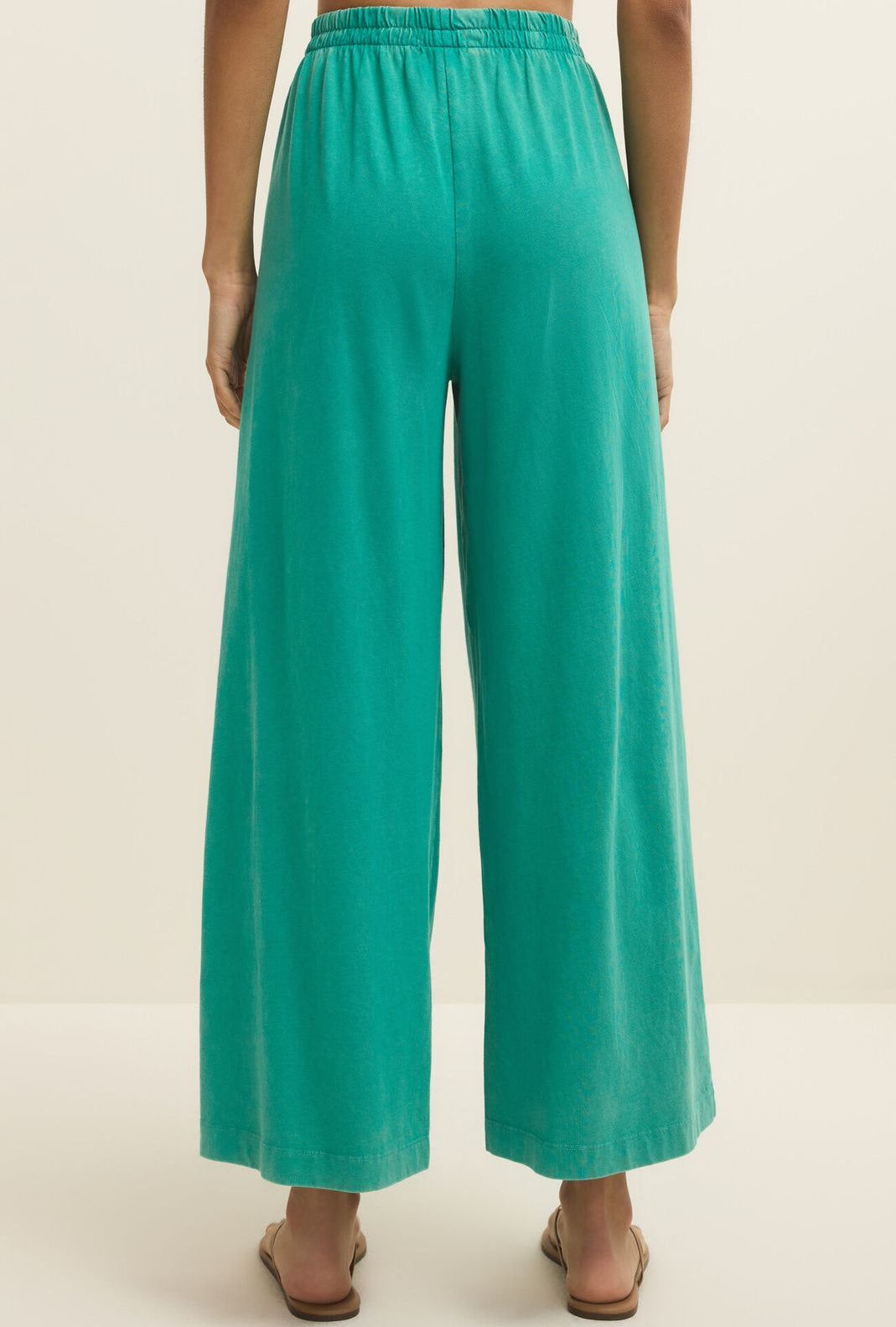 Teal wide-leg pants worn by a person on a plain background