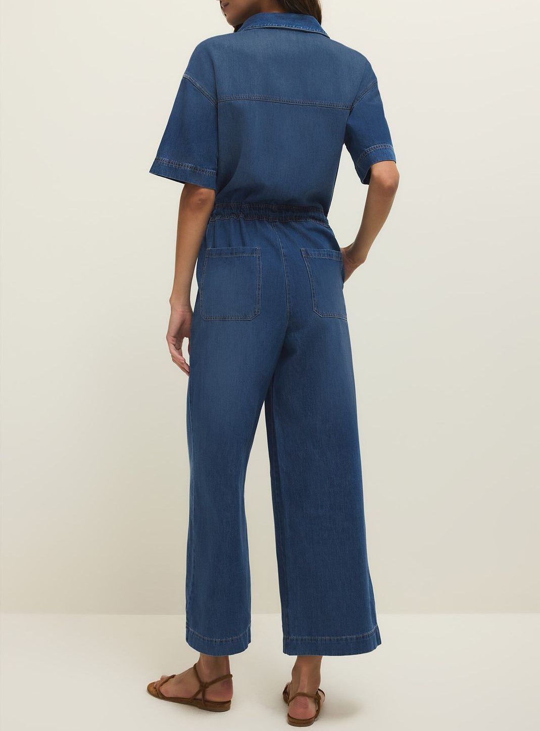 Woman wearing a blue jumpsuit on a white background