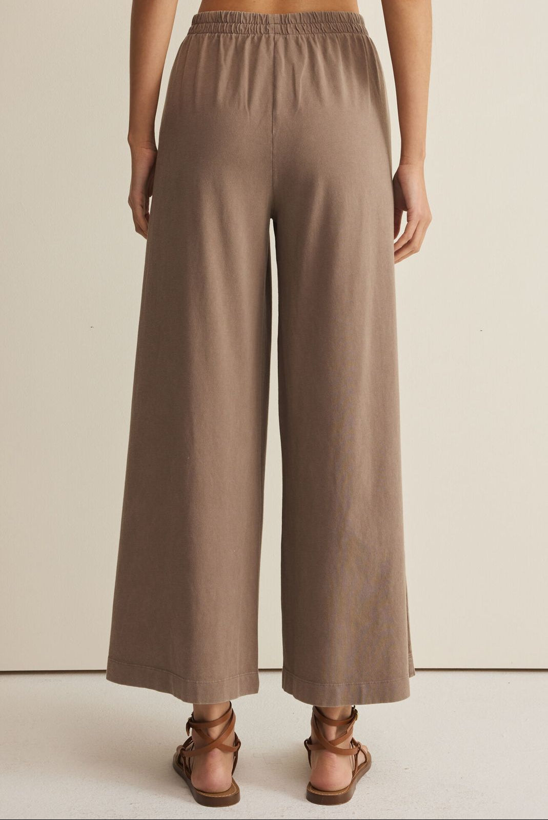 Brown wide-leg pants worn by a person on a neutral background