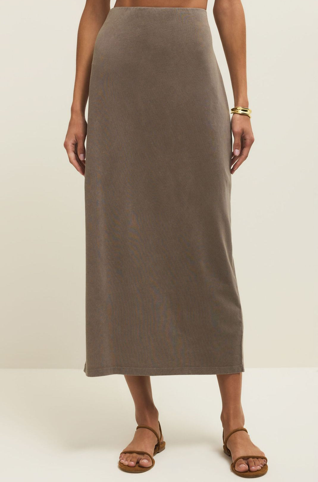 Person wearing a brown skirt on a plain background