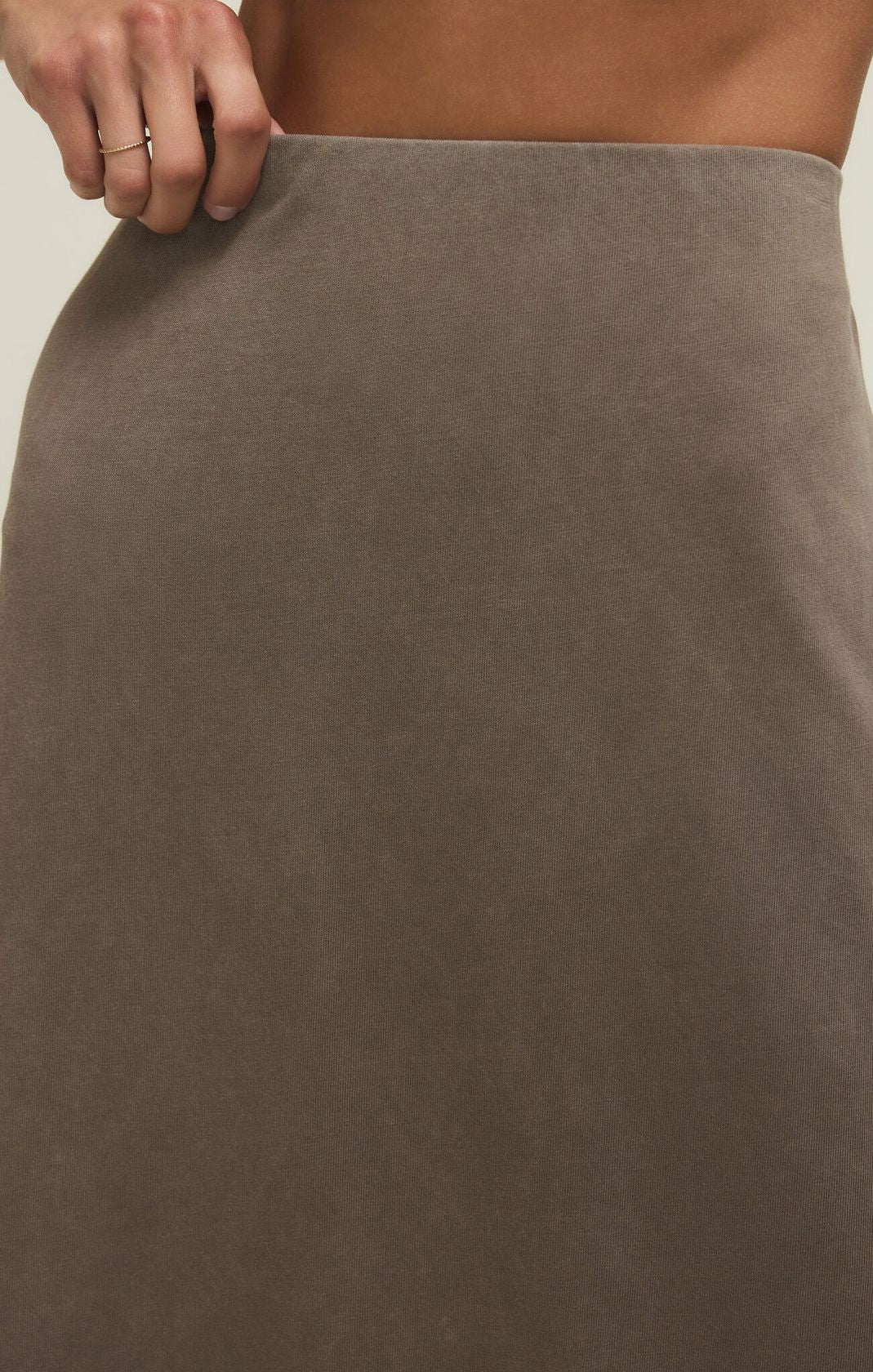 Brown skirt worn by a person with a neutral background
