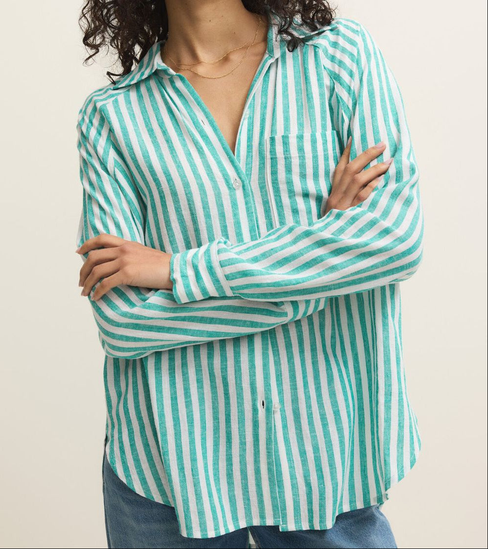 Woman wearing a green and white striped shirt against a beige background