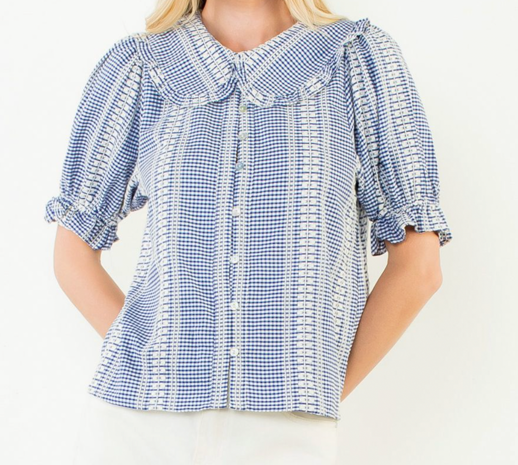Blue and white checkered blouse with ruffled details on a white background