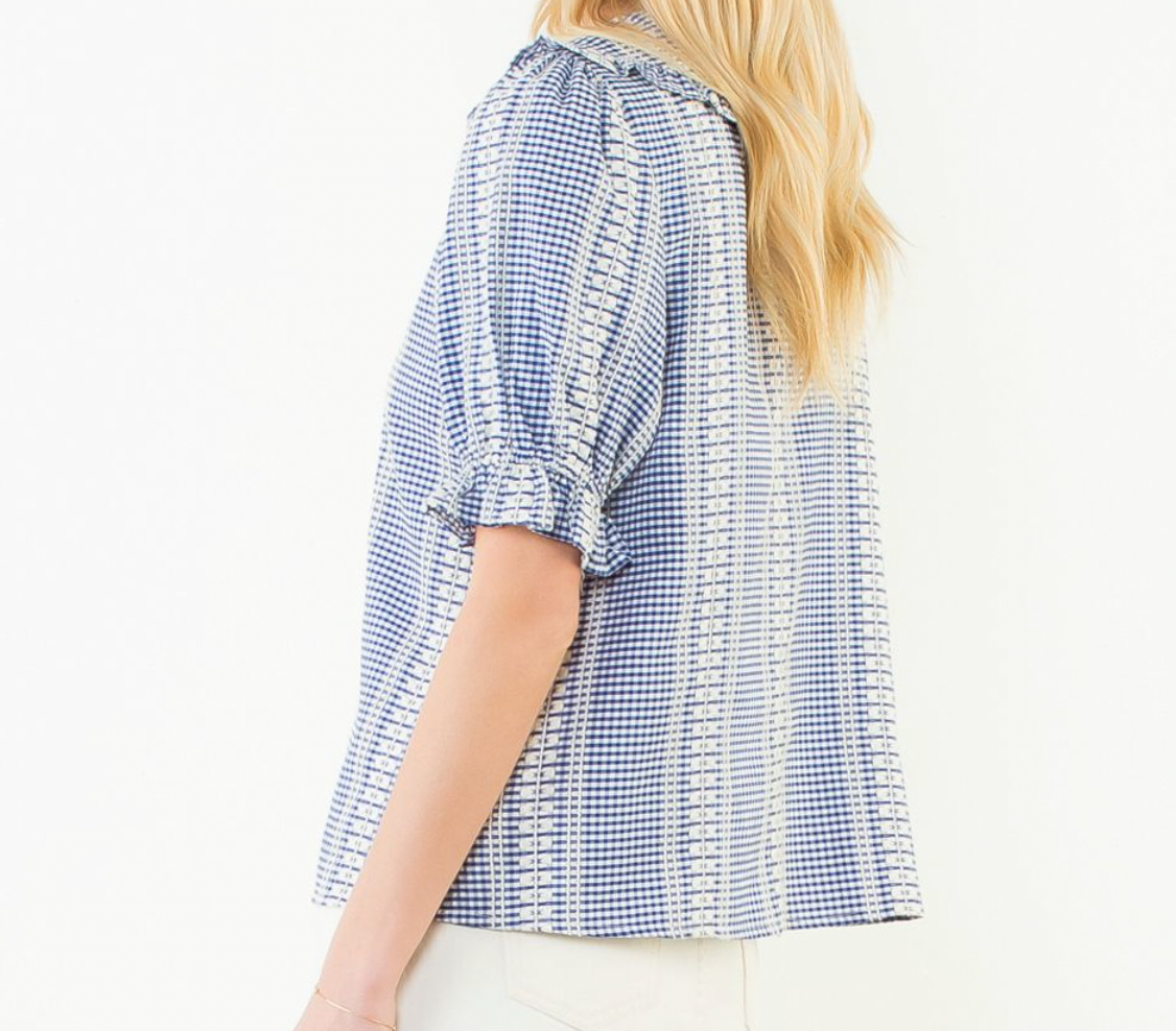 Side view of a woman wearing a blue and white checkered blouse on a white background