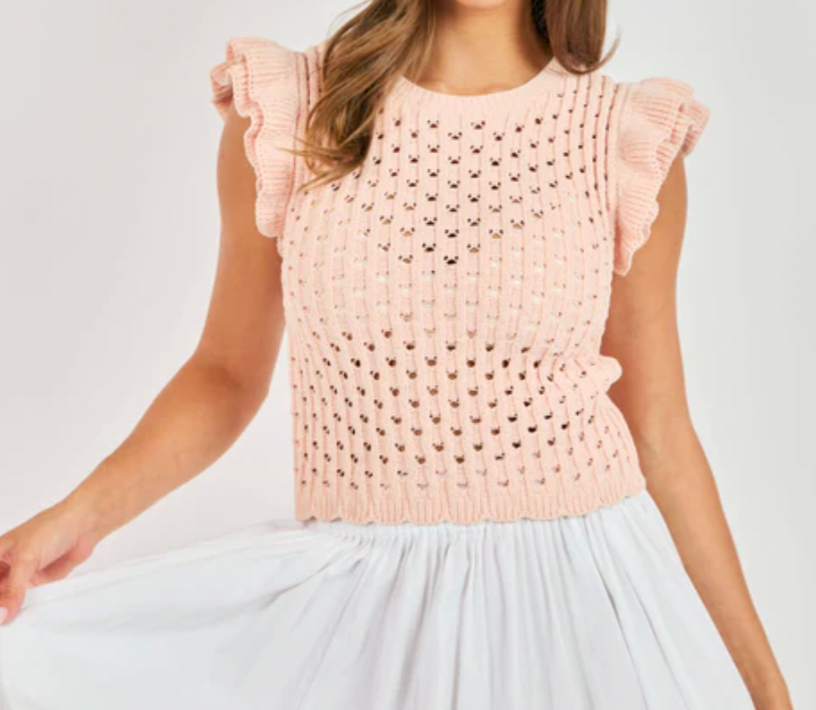 Light pink crochet top worn by a person on a white background