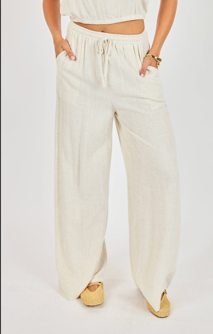Person wearing white wide-leg pants on a plain background