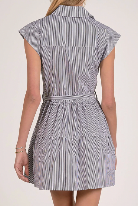 Woman wearing a sleeveless striped dress on a plain background