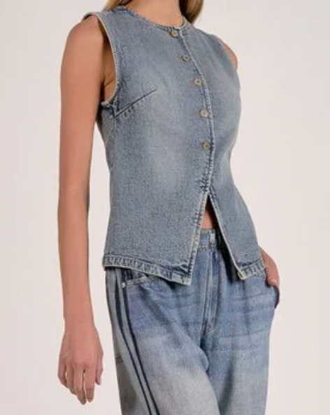 Person wearing a sleeveless denim top and jeans on a plain background