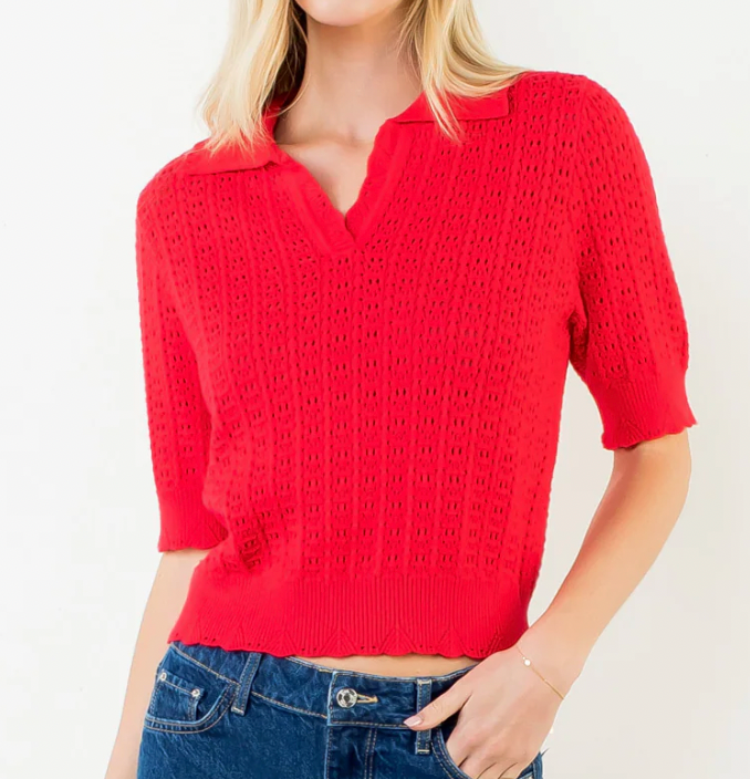 Red short-sleeve knitted top worn by a person on a white background