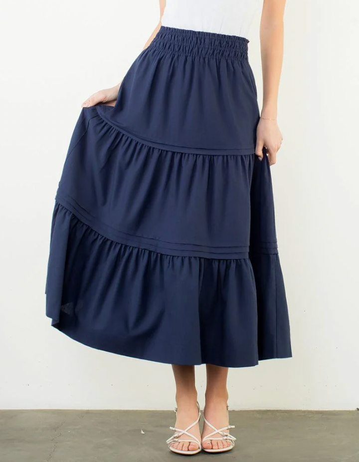 Navy blue tiered skirt worn by a person on a white background