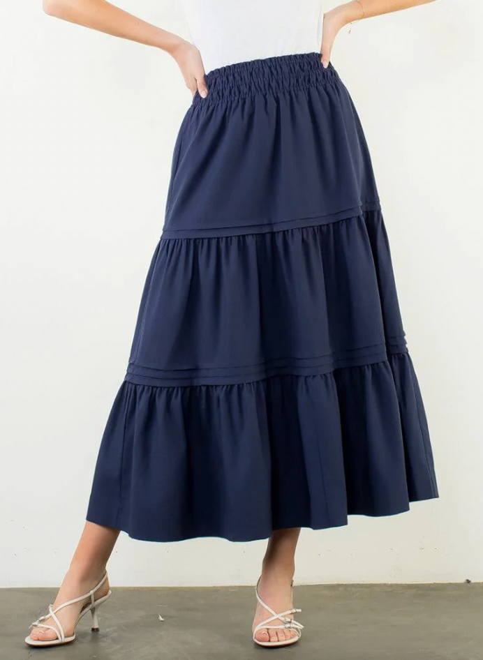 Navy blue tiered skirt worn by a person on a white background