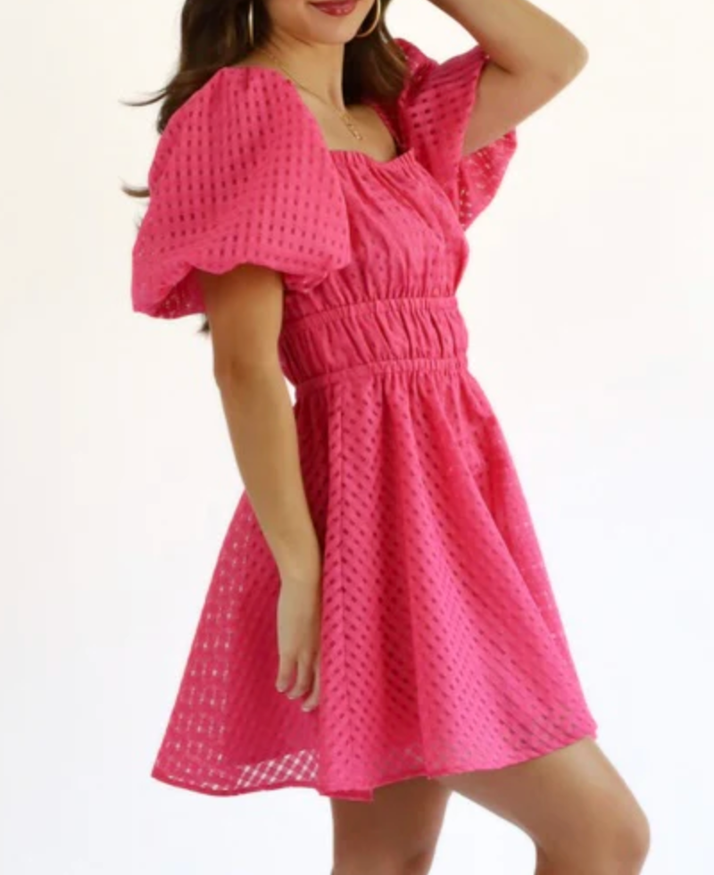 Woman wearing a pink dress with a white background