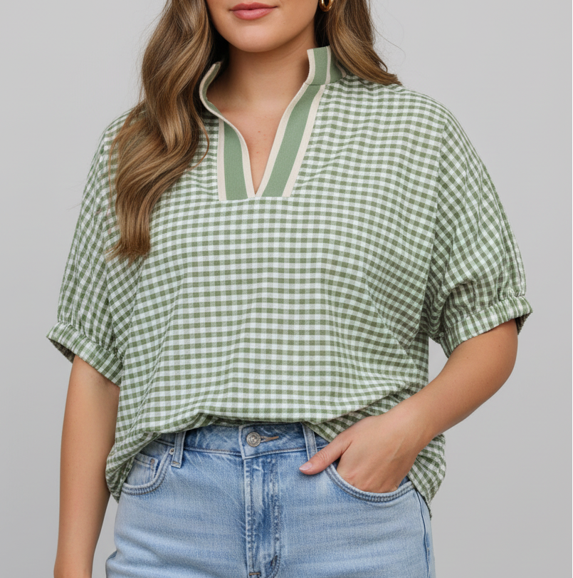 Woman wearing a green checkered blouse and light blue jeans outdoors.