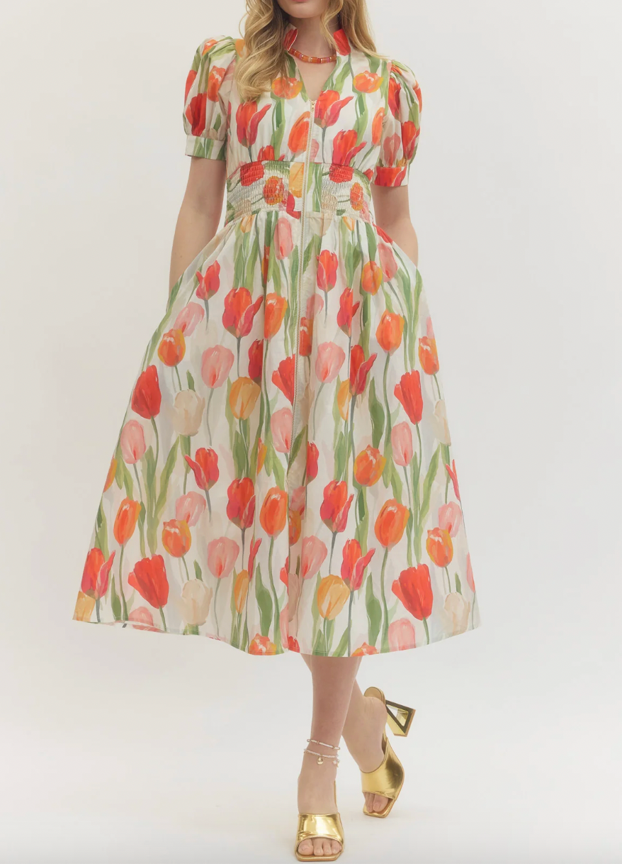 Woman wearing a floral dress with tulip pattern on a plain background