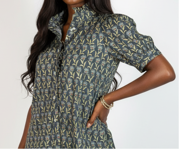 Woman wearing a patterned dress with puff sleeves against a white background