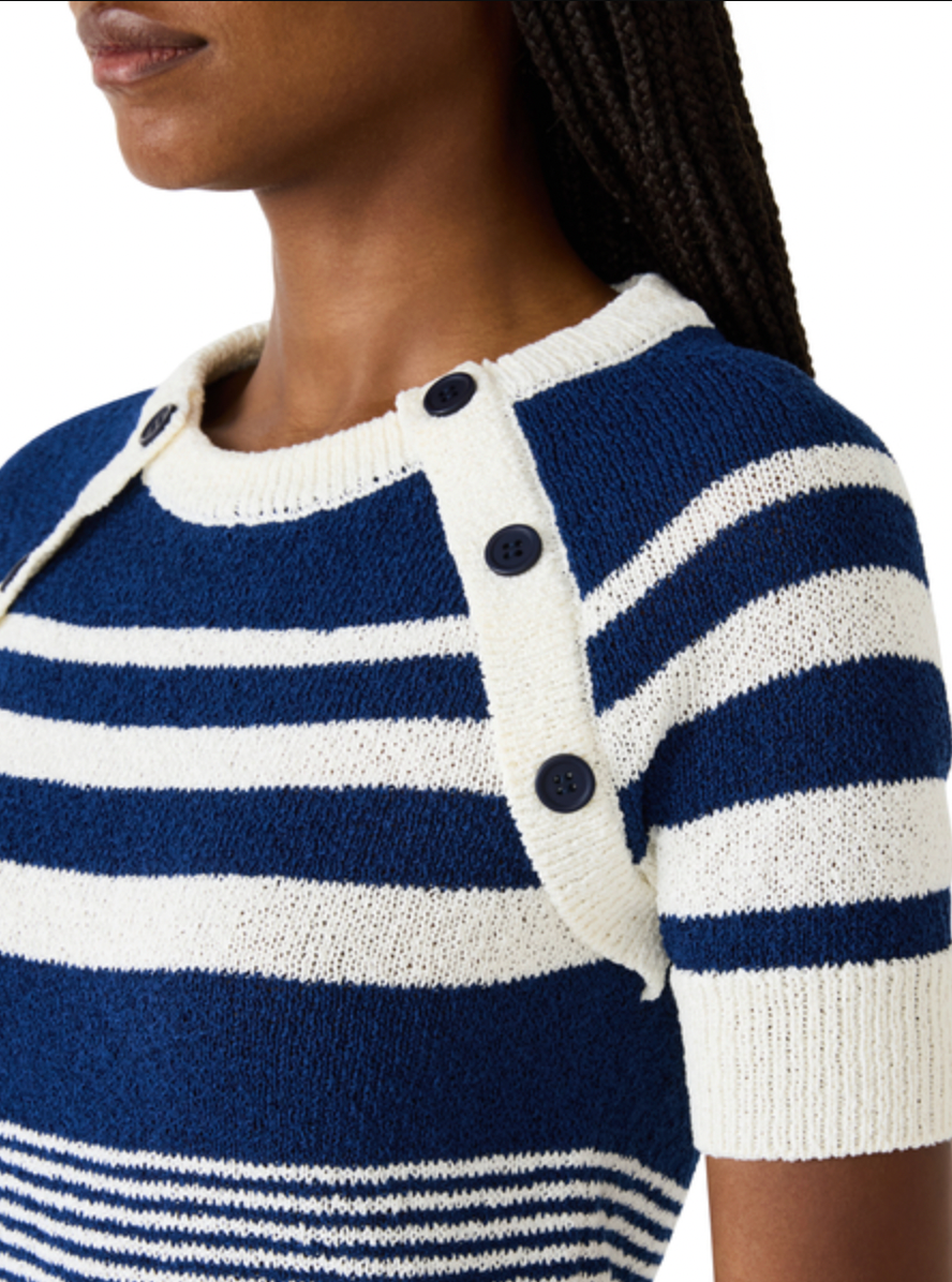 Close-up of a person wearing a blue and white striped sweater with button details.