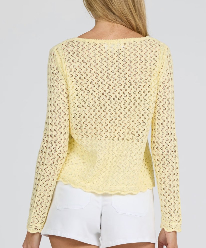 Yellow lace top worn by a person on a plain background