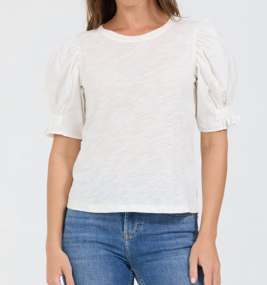 Person wearing a white t-shirt and blue jeans on a plain background