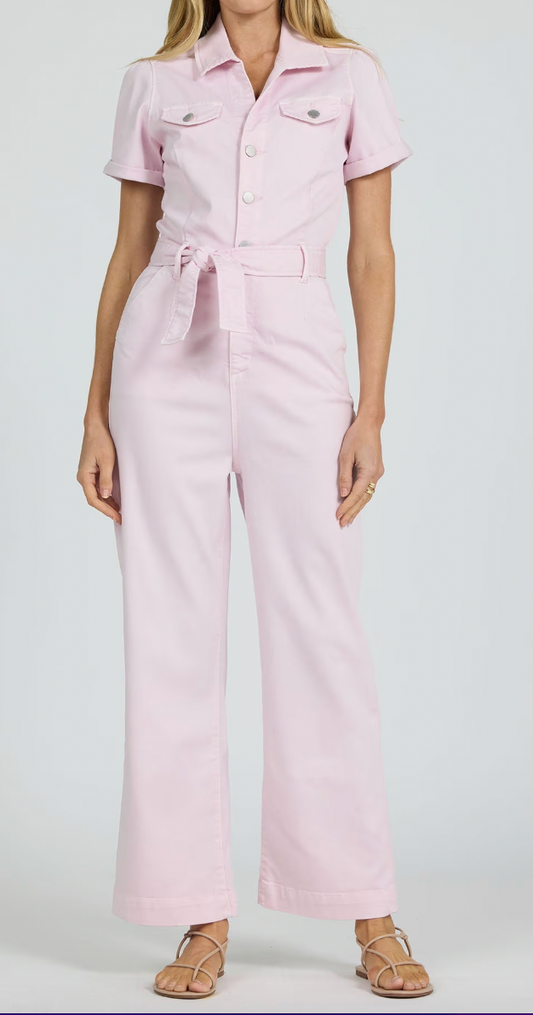 Person wearing a light pink jumpsuit on a white background