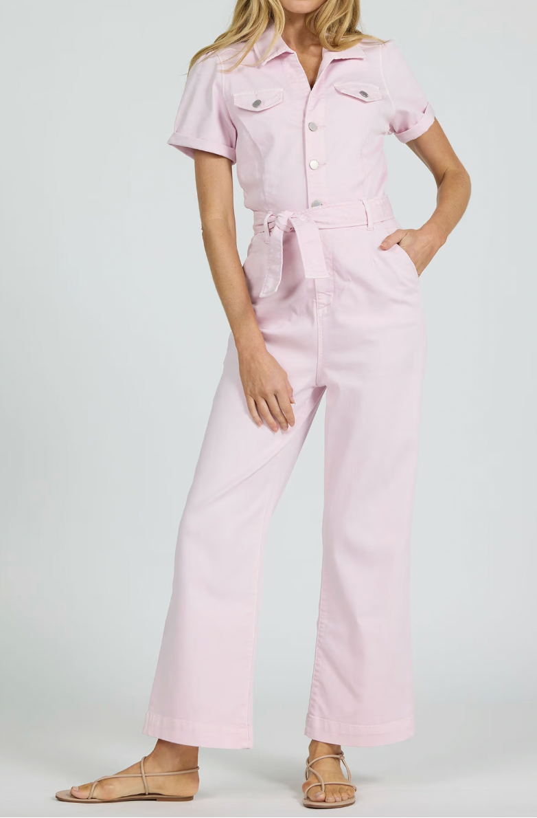 Woman wearing a light pink jumpsuit on a white background