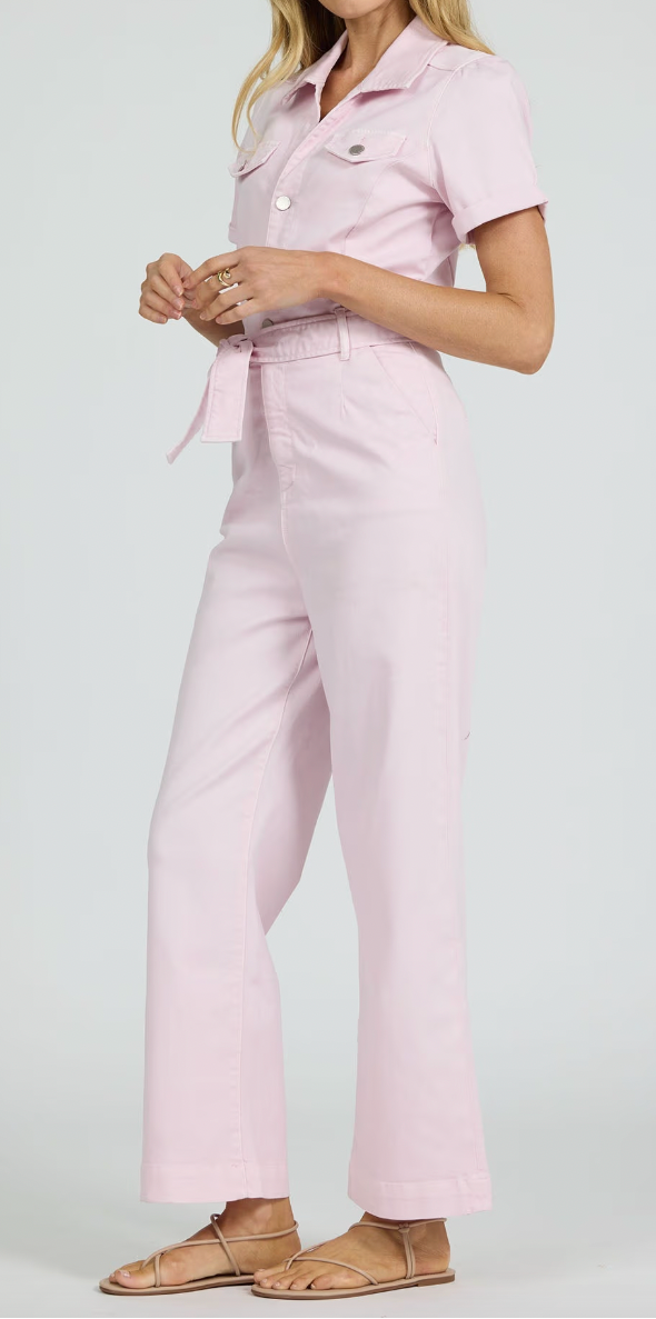 Woman wearing a light pink outfit with a shirt and pants on a white background