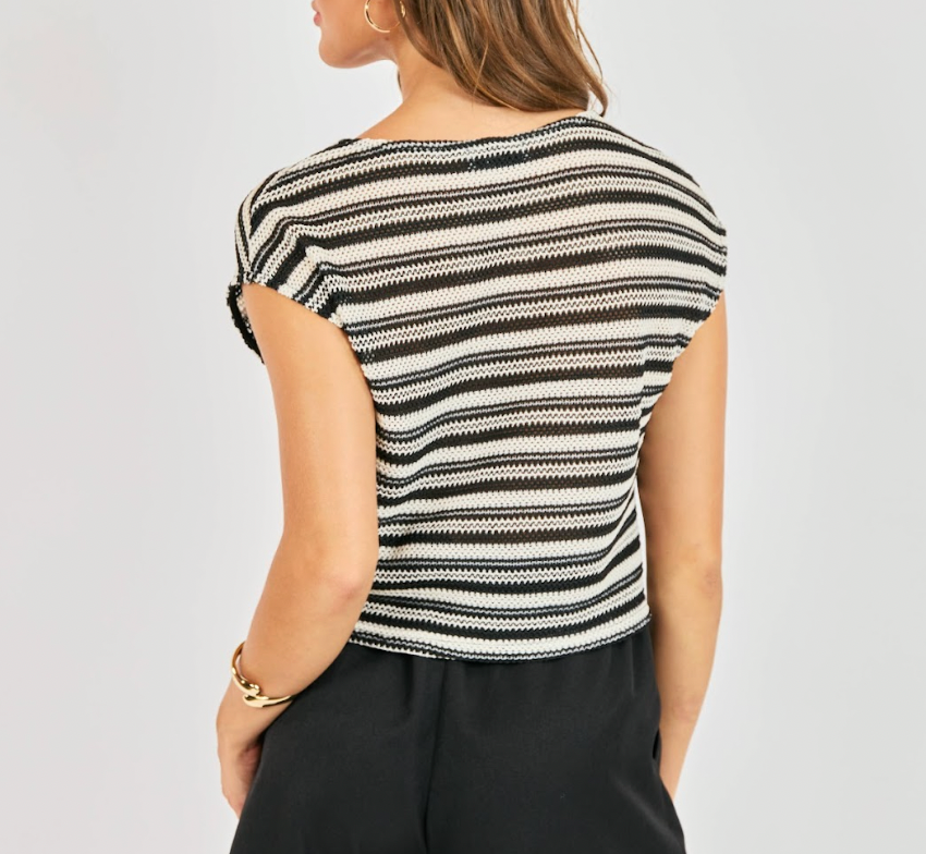 Woman wearing a black and white striped top on a plain background