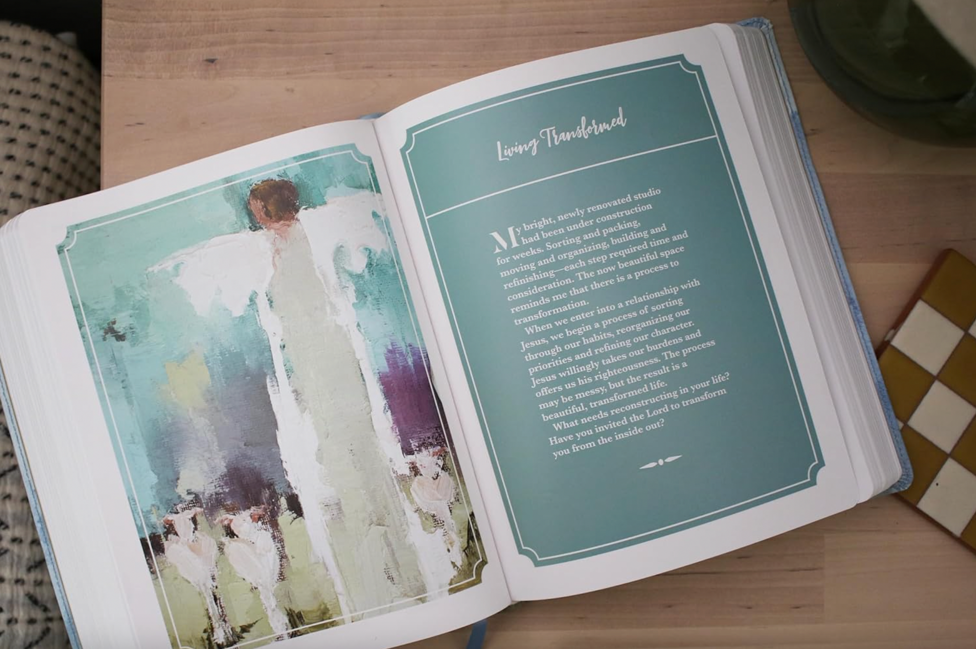 Open book with an illustration of a woman in a white dress on one page and text on the other, on a wooden surface.