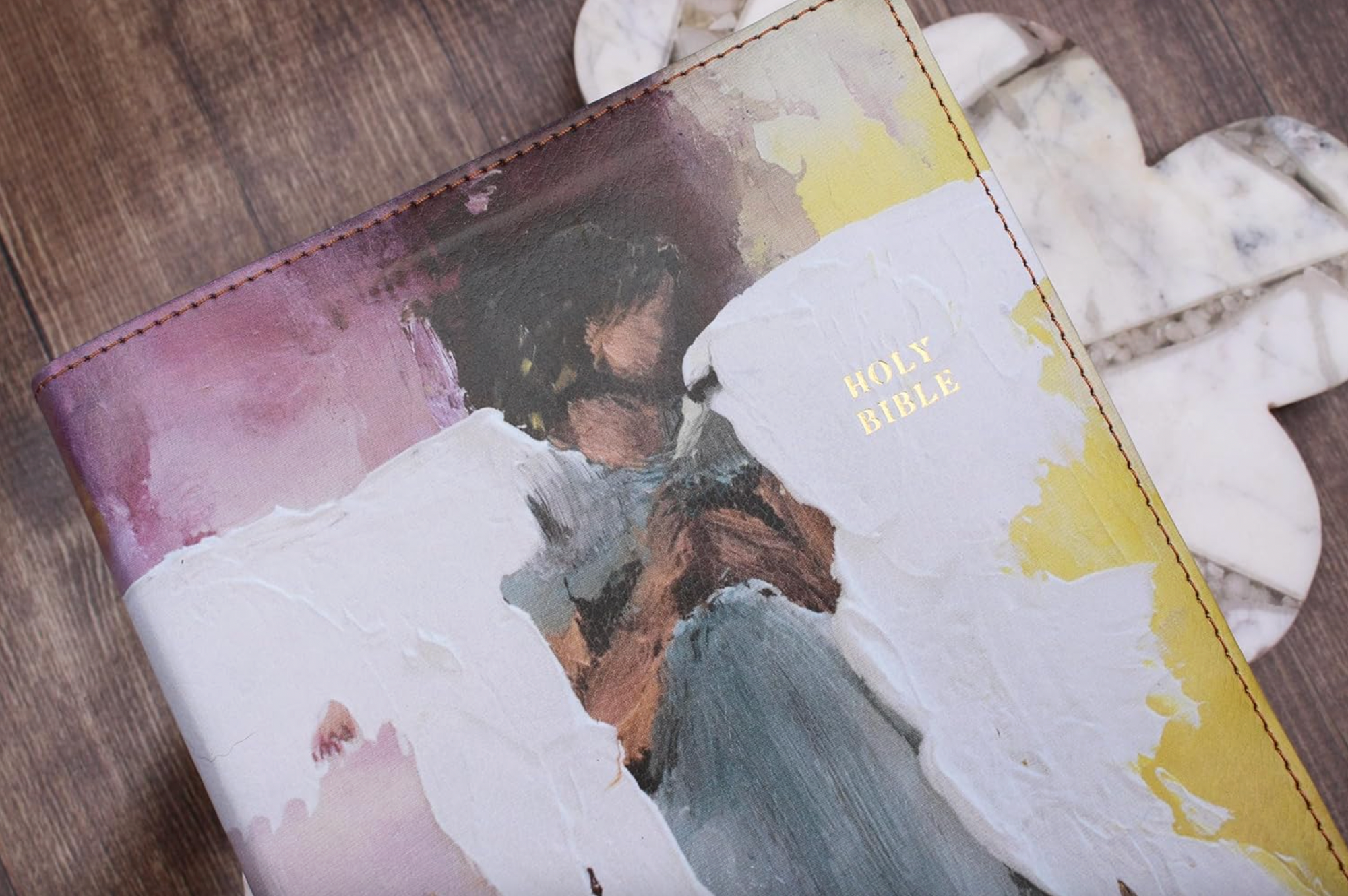 Decorative Bible cover with artistic design on a wooden surface