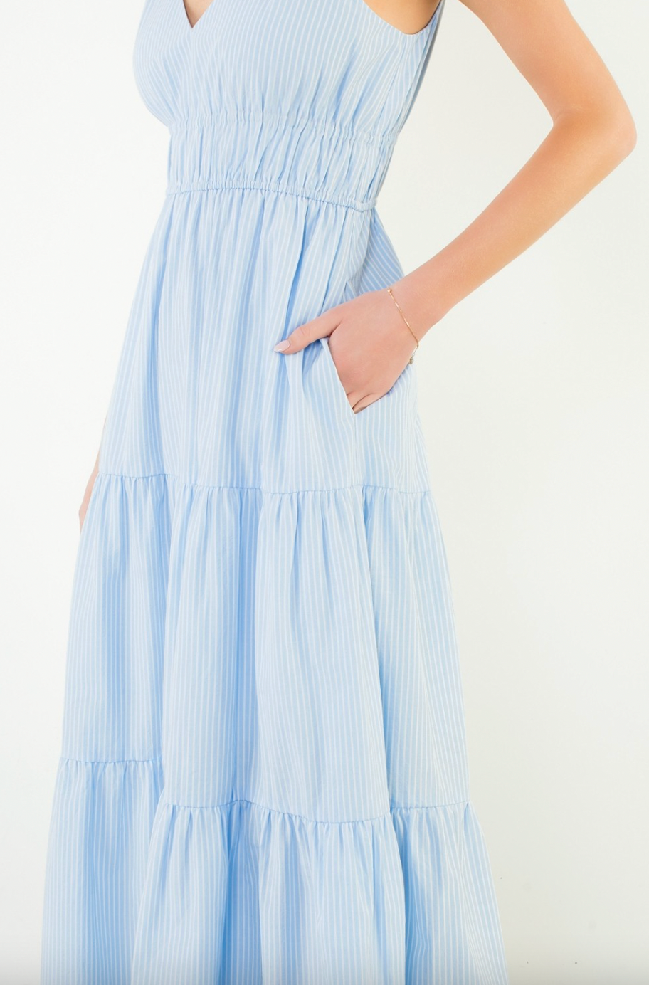 Light blue tiered dress worn by a person on a white background
