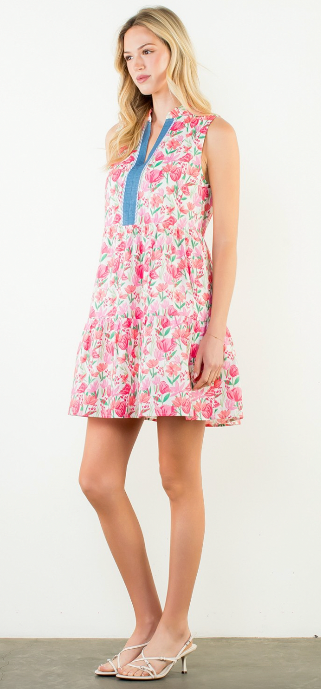 Woman wearing a floral dress with a blue collar on a white background