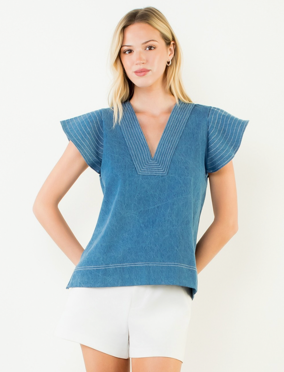 Woman wearing a blue top with short sleeves on a white background