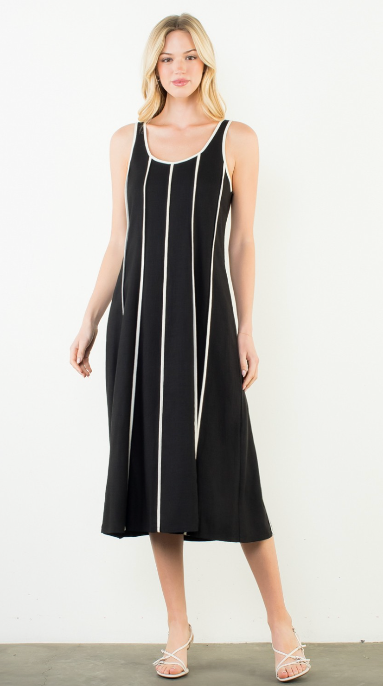Woman wearing a black dress with white stripes on a white background