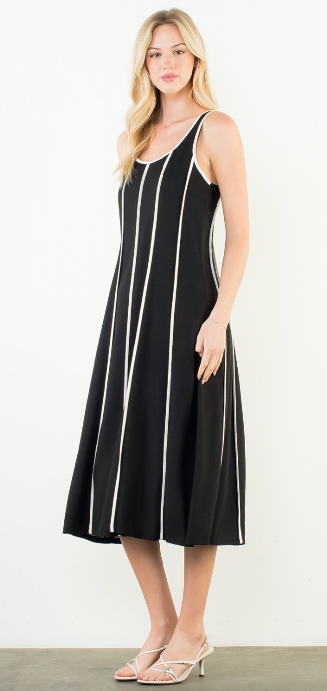 Woman wearing a black dress with white stripes on a white background
