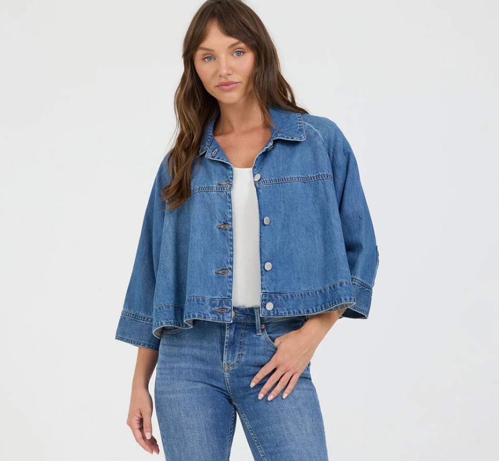 Woman wearing a blue denim jacket and jeans on a white background