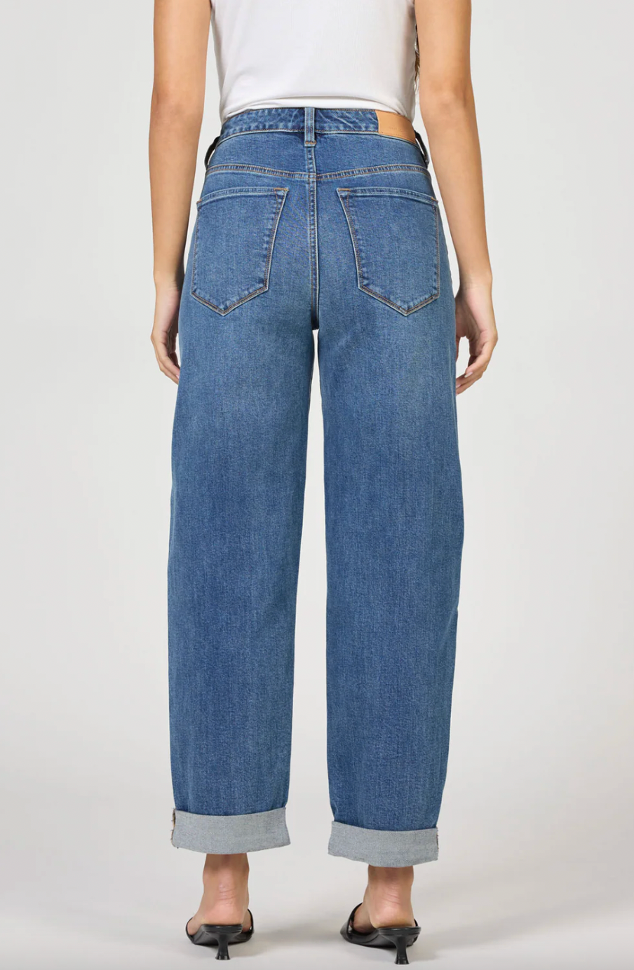 Blue jeans worn by a person on a white background